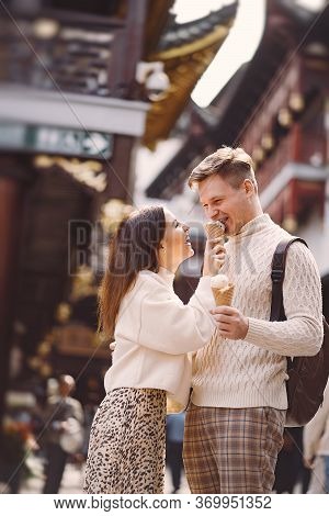 Newlywed Couple Eating Ice Cream From A Cone On A Street In Shanghai Near Yuyuan China.