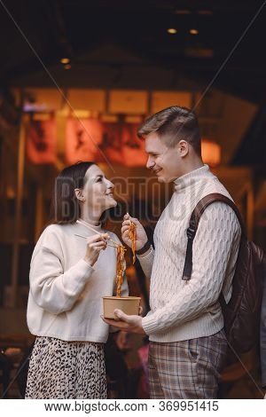 Newlywed Couple Eating Noodles With Chopsticks In Shanghai Outside A Food Market