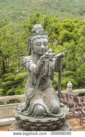 Buddhist Deva Statue Offering Fruit To The Tian Tan Big Buddha  Statue On Lantau Island, Hong Kong