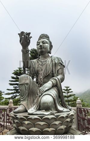 Buddhist Deva Statue Offering A Flower To The Tian Tan Big Buddha  Statue On Lantau Island, Hong Kon
