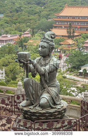 Buddhist Deva Statue Offering Incense To The Tian Tan Big Buddha  Statue On Lantau Island, Hong Kong