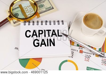 Business Concept. On The Table Is A Cup Of Coffee, Money, Business Charts And A Notepad With The Ins