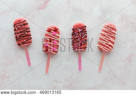 Decorated Valentine Cakesicles With Candy Melt Drizzle And Sprinkles.