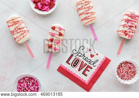 Homemade Decorated Cakesicles For Valentines Day With Bowls Of Sprinkles.