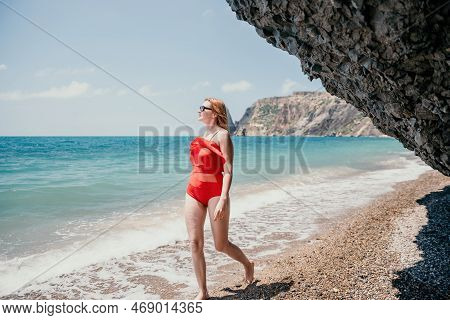 Young Woman In Red Bikini On Beach. Blonde In Sunglasses On Pebb