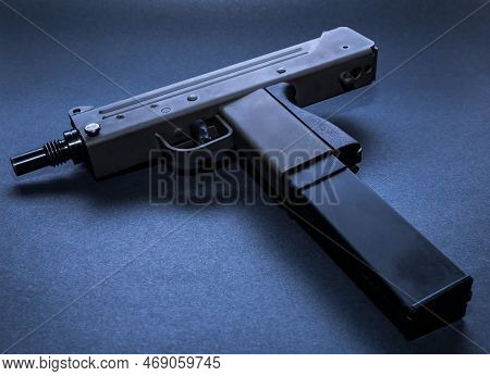 An Uzi Mini Machine Gun With An Extended Magazine On A Black Background