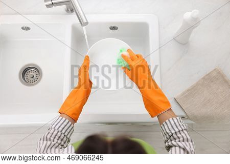Woman Washing Plate Above Sink In Modern Kitchen, Top View