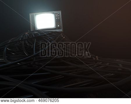 An Illuminated Vintage 80's Television Perched On A Jumbled Pile Of Black Cables On A Dark Omnious B