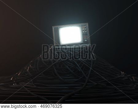An Illuminated Vintage 80's Television Perched On A Jumbled Pile Of Black Cables On A Dark Omnious B