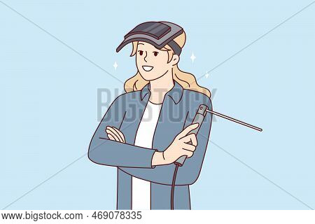 Woman With Welding Machine And Mask Protecting Eyes Stands With Arms Crossed And Looks Forward Smili