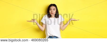 Clueless Asian Girl Shrugging Shoulders, Spread Out Hands And Looking Confused, Know Nothing, Standi