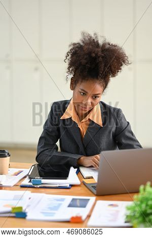 Smiling African Female Manager Using Laptop And Working With Financial Docent In Her Personal Office