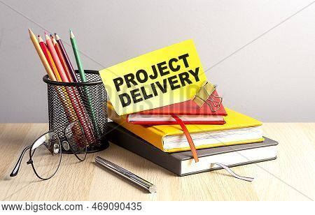 Project Delivery Written On Sticky On Notebooks
