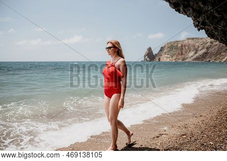 Young Woman In Red Bikini On Beach. Blonde In Sunglasses On Pebb