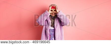 Fashion And Shopping. Happy Asian Grandmother In Stylish Faur Fur Coat, Looking Through Hand Glasses