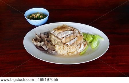 Boiled Chicken, Offal With Cucumber Sliced On White Dish And Small Bowl Spicy Or Sweet Sauce On Dark