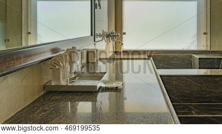 On The Marble Countertop In The Bathroom There Are Glasses, Soap Dish, Napkins.  Mirror On The Wall.