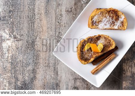 Traditional Homemade Spanish Torrijas Decorated With Cinnamon And Orange Peel On Wooden Table. Top V