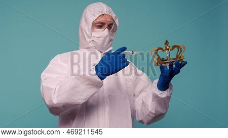 A Male Doctor In Protective Overalls And A Mask Makes An Injection In The Crown. Coronovirus Protect