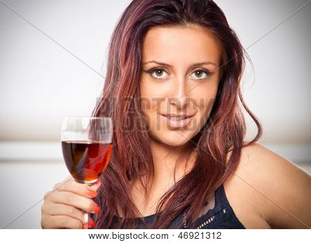 Portræt af ung glad smilende munter smuk kvinde med glas rødvin. Hun er dette års 