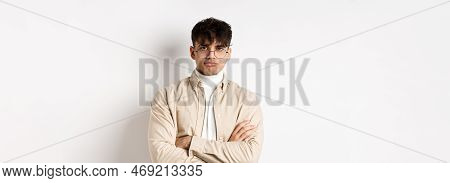Image Of Stylish Hipster Guy In Glasses Feeling Bored, Looking Unamused With Pokerface, Cross Arms O