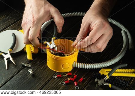 Cutting The Wire In The Yellow Junction Box. Electrical Connection In The Workshop Of A Professional
