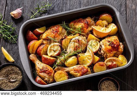 Lemon Garlic Chicken With Roasted Potatoes, Spices And Herbs On Sheet-pan On Dark Wood Table With Ng