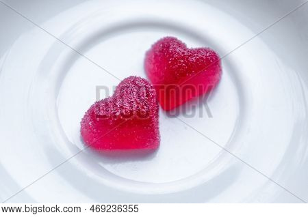 Two Red Sugar Marmalade Candies In Shape Of A Heart On A White Plate