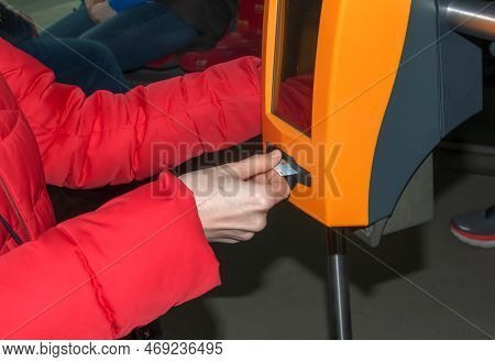 Young Stylish Woman Using A Ticket Punching Machine In Public Transport. The Girl Punches The Ticket