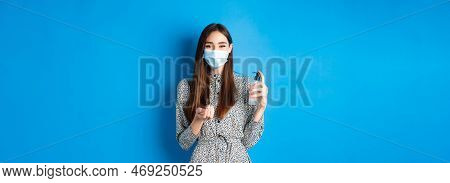 Covid-19, Social Distancing And Healthcare Concept. Beautiful Girl In Medical Mask Using Hand Sanizi