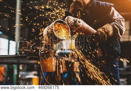 Profesional Fabric Worker In Protective Uniform Cutting Metal Pipe On The Work Table With An Electri