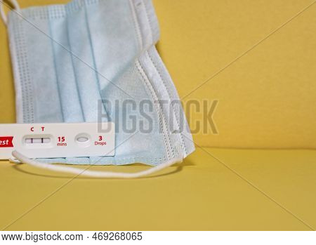 Positive Covid Test In Front Of A Paper Mask