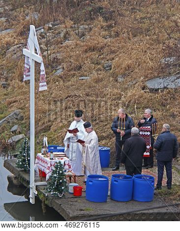 Two Priests Begin For The Rite Of Epiphany. Voron River In Tysmenytsia, Ivano-frankivsk Region, Ukra