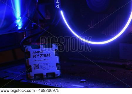 Close-up Of An Amd Ryzen 9 3900X Processor, Against The Backdrop Of Coolers With Light.