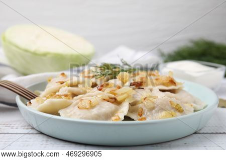 Cooked Dumplings (varenyky) With Tasty Filling, Fried Onions And Dill On Wooden Table, Closeup