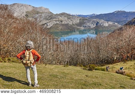 Picturesque Reservoir And Mountain Landscape In Riano. Hikers. Spain