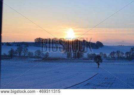 Orange Sunrise Above The Snow Covered Eifel Landscape