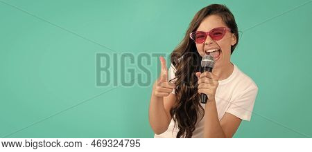 Happy Girl Singer Point Finger Gun Singing Song To Microphone Blue Background, Karaoke. Horizontal P