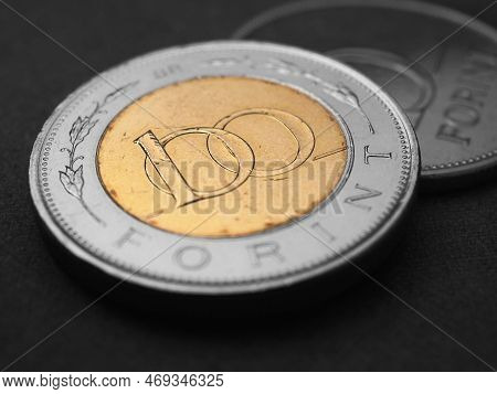 Hungarian Coin Of 100 Forints Lies On Dark Black Surface Closeup. Money Of Hungary. News About Econo