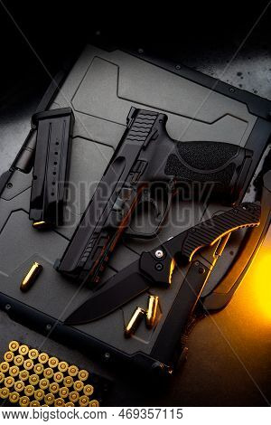 A Pistol, Cartridges For It And A Folding Knife On A Dark Background. Self-defense And Survival Kit.