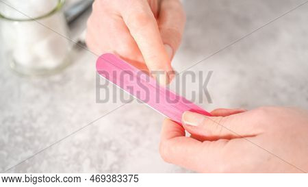 Woman Finishing Her Manicure At Home With Simple Manicure Tools. Filing Nails With A Nail Filer.