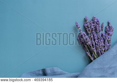 Lavender Flowers And Kitchen Nepkin On Colored Background Top View. Copy Space.