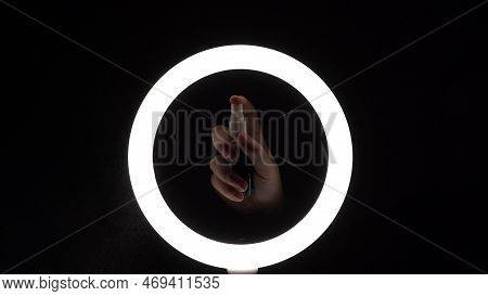 Atomizer In Female Hands. Spraying Water. Sprinkling Liquid Closeup. Water Dust On A Black Backgroun