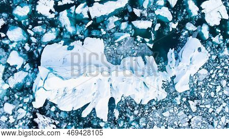 Melting Arctic Ice In Ocean Water. Blue Glacier Ice Covered With Snow In Iceland. Climate Crisis