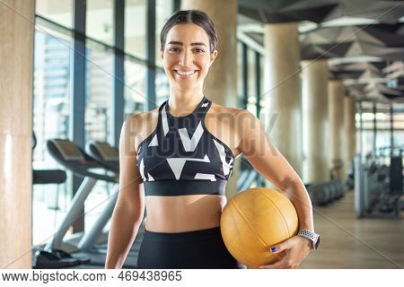 Beautiful Young Sporty Woman Holding Fitness Ball At Gym.