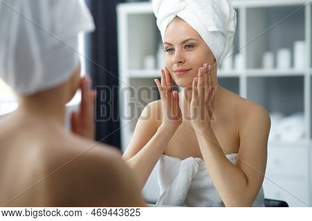 Young Woman Sits In The Bathroom In Front Of The Makeup Mirror And Does Cosmetic Procedures. Beautif