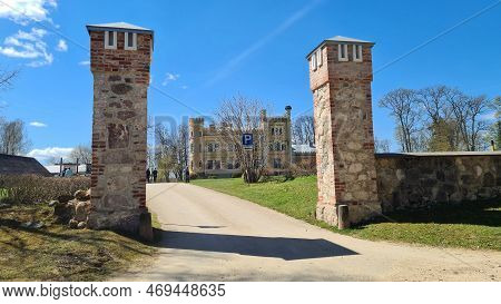 Old Manor Between Stone Pillars Of The Gate In The Latvian Village Of Garsene On A Sunny May Day 202