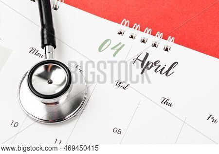 Stethoscope Medical And April 2023 Desk Calendar On The Red Background, Schedule To Check Up Healthy