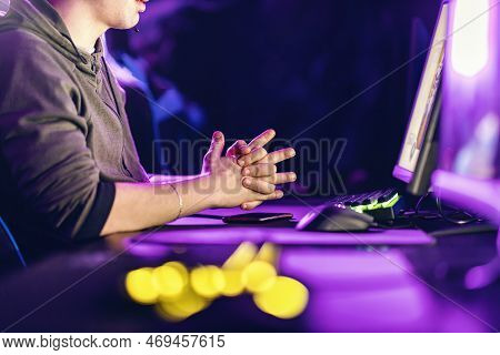 A Tensed Gamer Nervously Holding Hands While Looking At Video Game In Gaming Room.