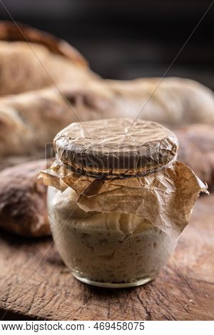 Rye Sourdough Ripened In A Jar Together With Fresh Bread On A Cutting Board.